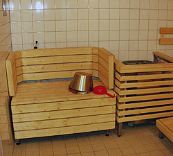 Tilgængelig sauna med afskærmet ovn og særlig siddeplads, som kan hæves og sænkes, så brugeren kan justere varmen.