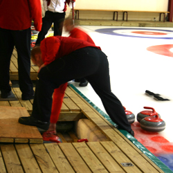 Stenene til curling opbevares under gulvet i kanten af banen - ramper bør ligeledes være integreret i kanten